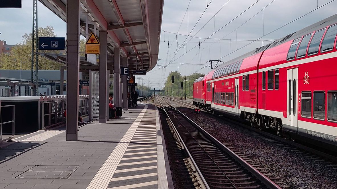 rote DB Regio Bahn steht im Bahnhof am Gleis