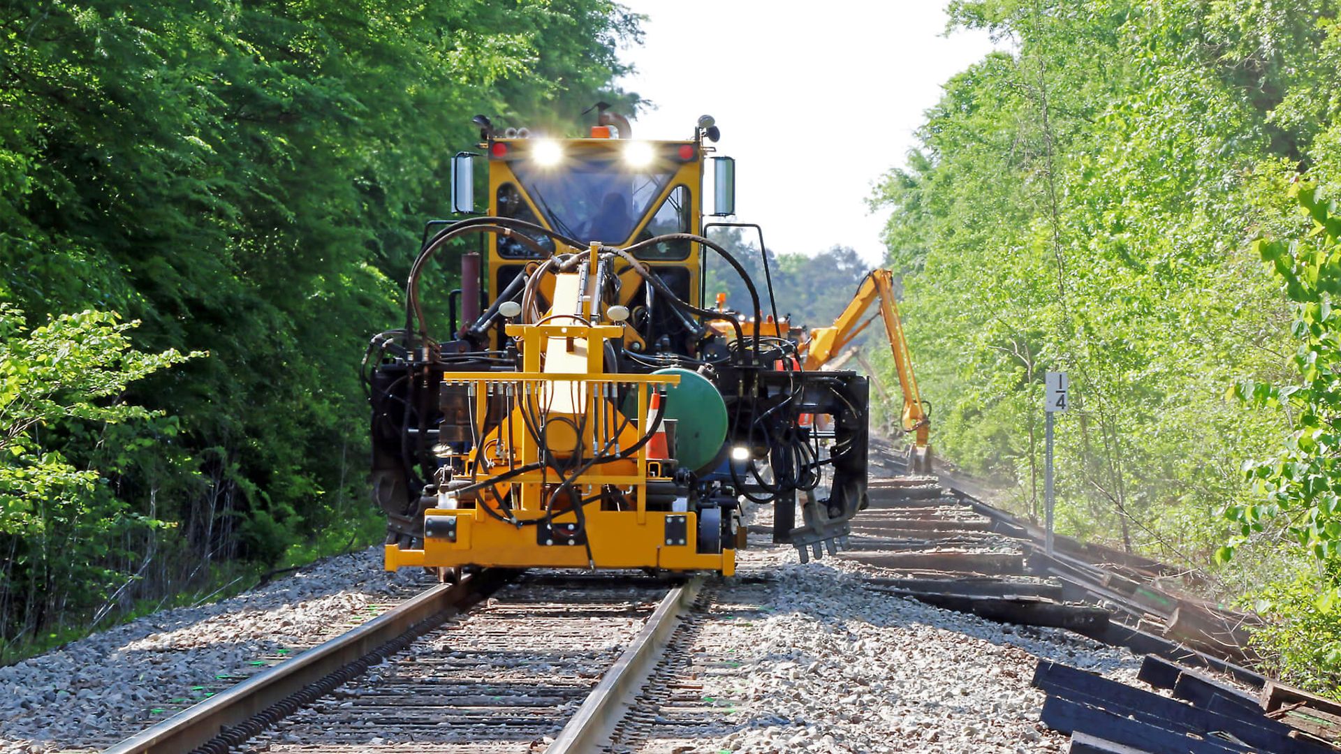 Ein Maschine steht auf den Gleißen. In einer ländlichen Gegend