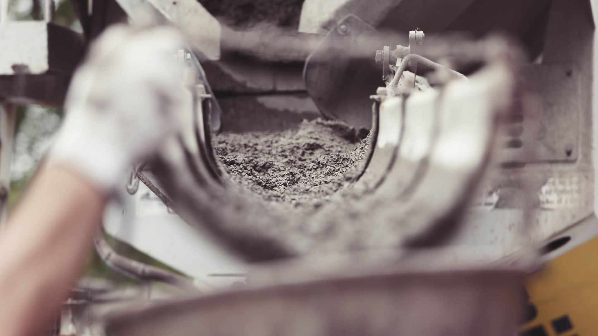 Detailaufnahme mit großem unscharfen Bereich im Vordergrund. Es ist der Blick durch die Betonrutsche in die Betonmischmaschine.