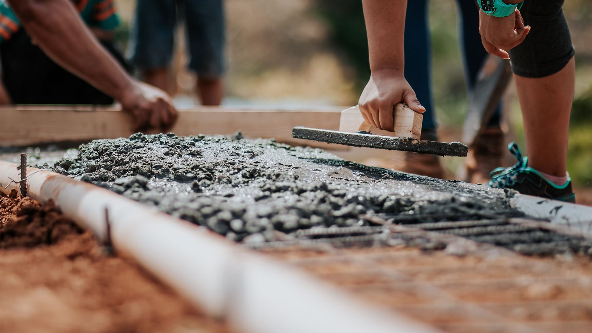Nahaufnahme während gerade der Beton in einer Verschalung verstrichen wird.