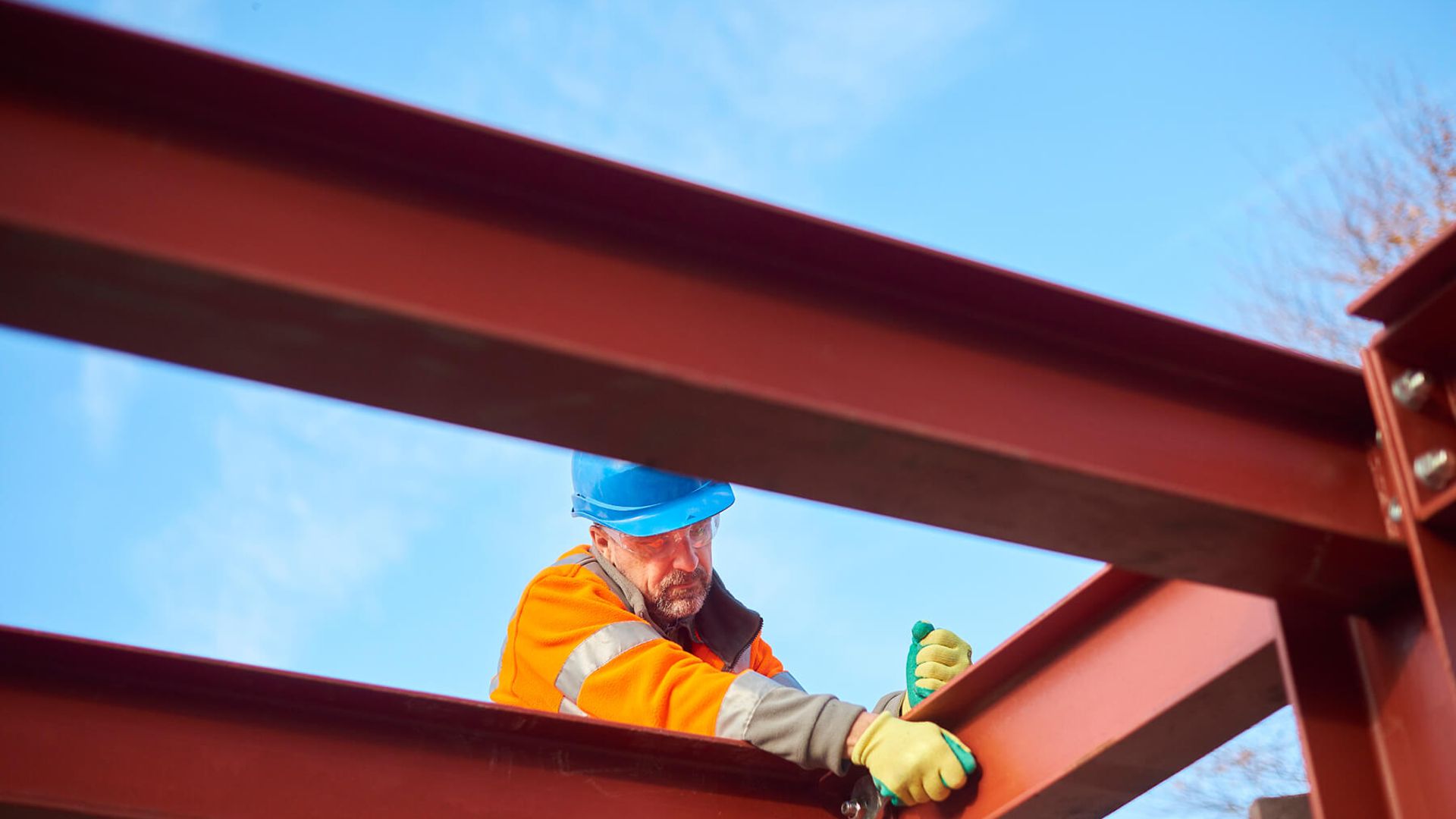 Ein Mann arbeitet auf Metallträgern.