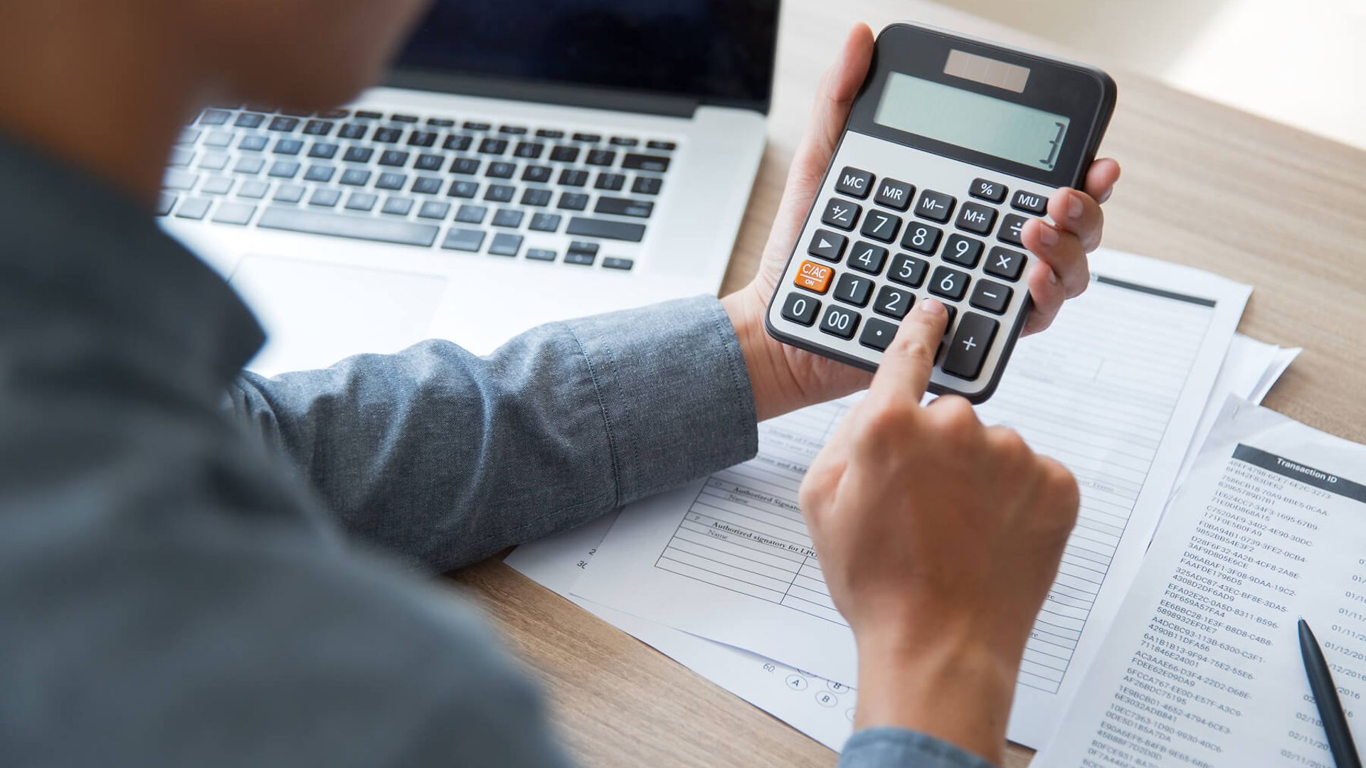 Eine Person bedient einen Taschenrechner.