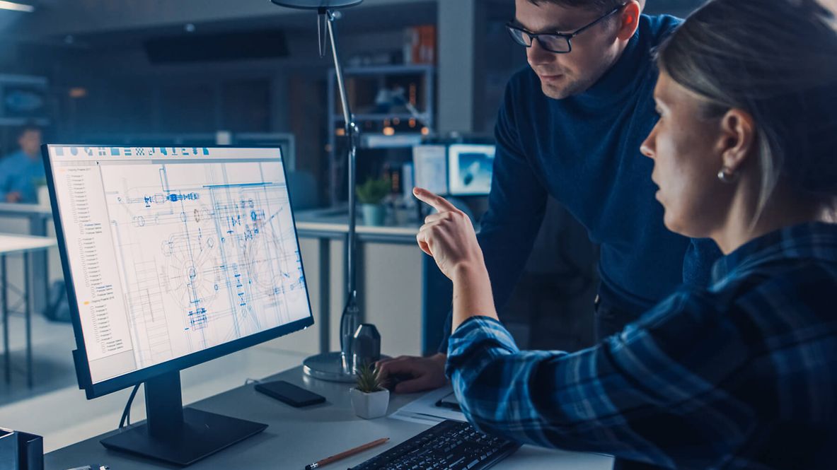 Zwei Personen unterhalten sich über einen Plan der auf dem Bildschirm angezeigt wird.